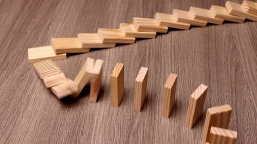 Dominosteine aus Holz, die in einer Kettenreaktion fallen, Ursache und Vernunft, Zusammenhang, Krise, Idee, Wirtschaft, Geschäft