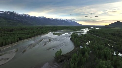 Drone View of Sunset Sky with Snowcapped Mountains and River Above
