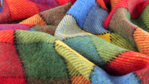 Top view of the soft folds of the bright textured multicolored wool fabric rotated
