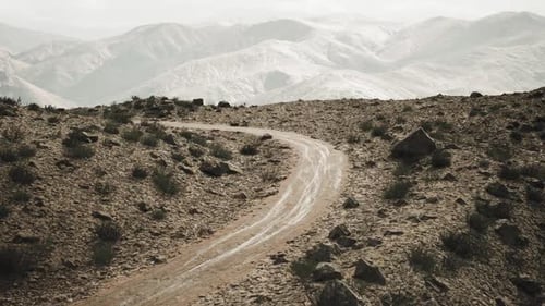 Route de terre sinueuse à travers les montagnes du Pamir au Tadjikistan pendant la journée