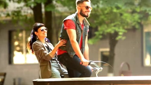 Jovem casal andando de bicicleta juntos no parque Namorado romântico andando de bicicleta com namorada feliz