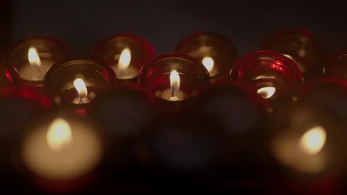 Glowing Votive Candles Burning in the Dark
