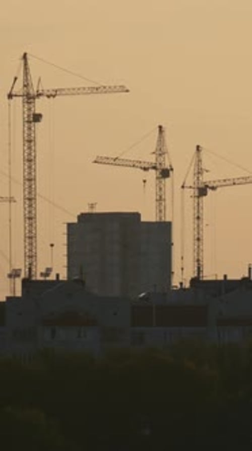 Construction Cranes on Construction Site at Sunrise