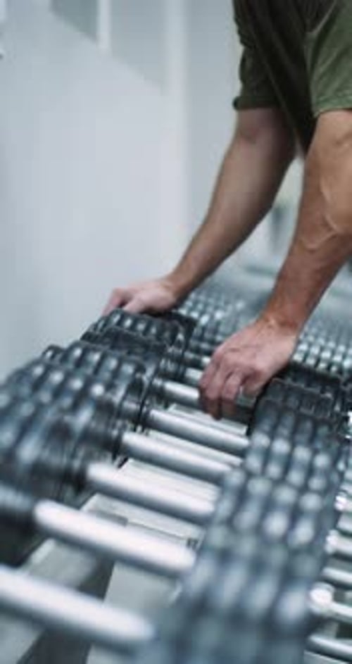 Cropped Footage of a Male Hand Picks Up Dumbbell From the Rack