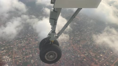 airplane aircraft Boeing wheel above cityscape up in the air with white clouds