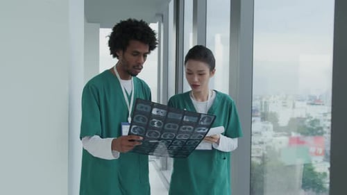 Two Diverse Therapists Examining MRI Scan, Walking along Clinic Hall