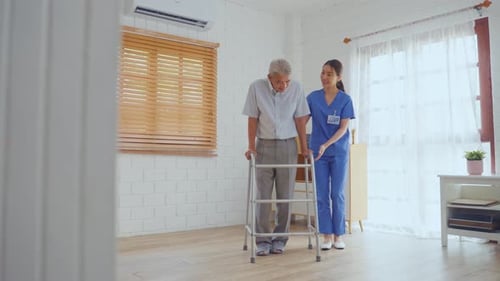 Man Using Walker With Nurse Assisting at Home