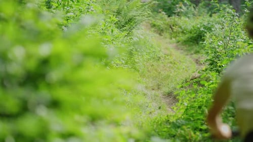 A cyclist rides down a dusty trail in slow motion