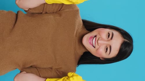 Smiling Woman in Gloves Points Upward