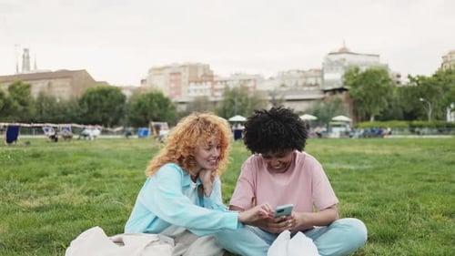 Multiethnic Friends Looking at Smartphone in City Park