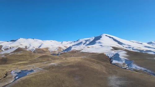 Majestic Snow-Capped Mountains Under Clear Blue Sky