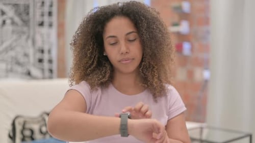 Woman Interacts with Smart Watch Device Indoors