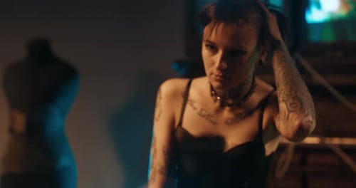 Sexy Woman with Tattoos Posing Seductively in Front of Web Camera in Studio Alternative Style of