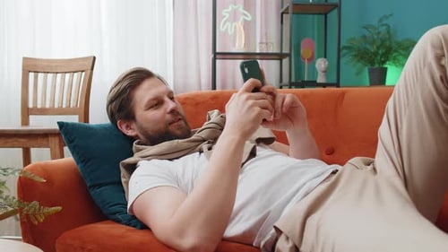 Young Adult Using Phone While Relaxing on Couch