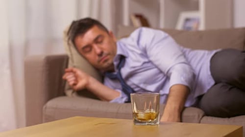 Man Lying on Sofa Taking a Drink