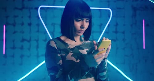 Woman Looks at Smartphone Screen Dislikes and Shakes Head