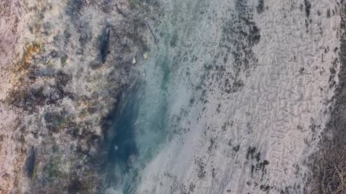 Aerial view of salmon swimming in a narrow, shallow stream along the Michigan shoreline during spawn