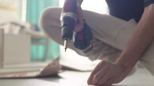 Adult Assembling Furniture Using a Cordless Drill