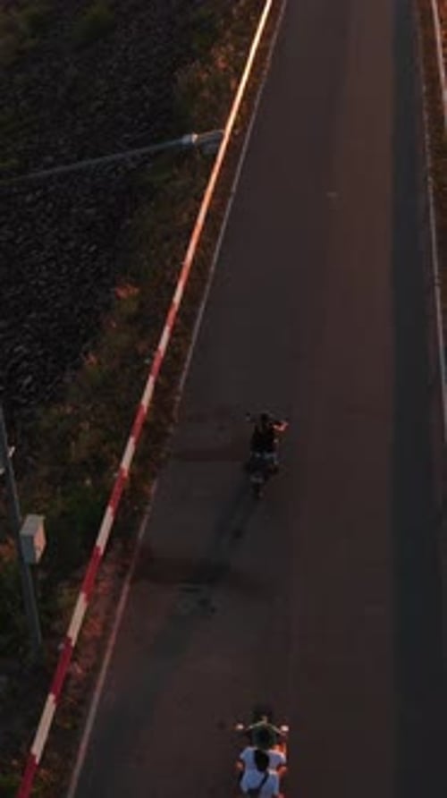 Un motocycliste profite d'une balade panoramique au coucher du soleil sur une route à côté de la crête d'un barrage