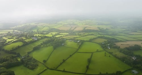 Misty Low Clouds Hovering Over Rolling Hills And Farms Aerial View