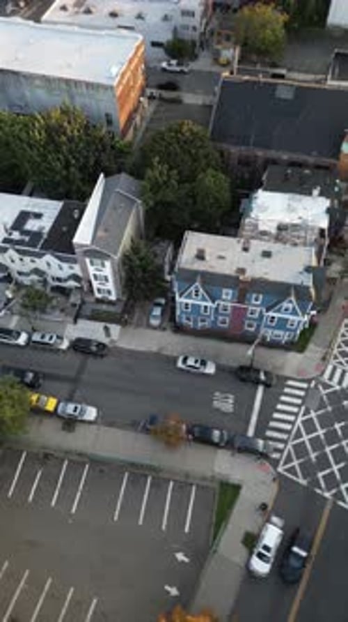Drone footage ascending from a residential street in jersey city, slowly tilting up to reveal the