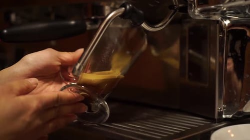 Coffee Machine prepares espresso in long glass coffee - CLOSE UP