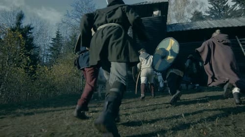 Medieval Battle Reenactment. Violent Tribe of Warriors Attacks Wooden Fortress, They Run Through th