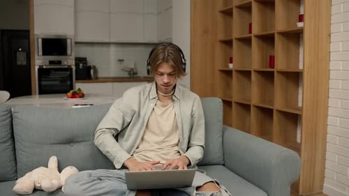 Young Adult Works on Laptop in Home