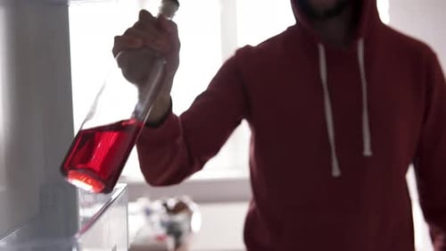 Person Removes Bottle from Refrigerator