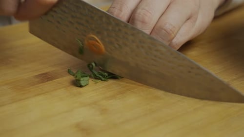 Chef Hands Chopping Fresh Herbs on Board