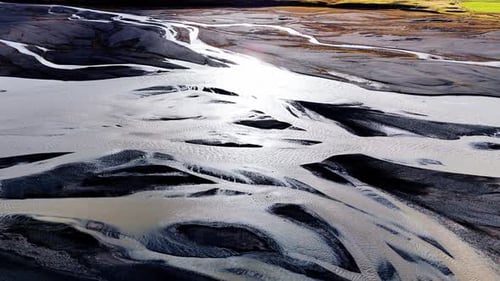 river braids with reflective sun light, Iceland.