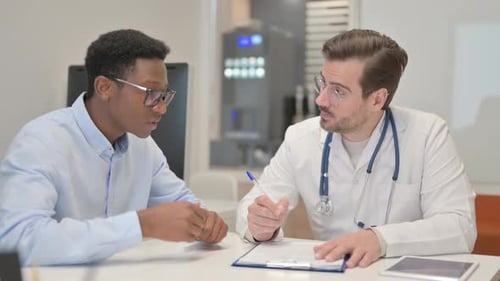 Doctor Consults Patient in Office Writing Notes