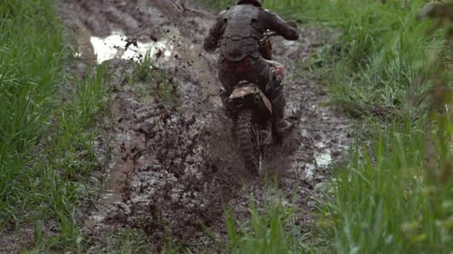 Motorcycle Rider Splashing Through Muddy Path in Nature