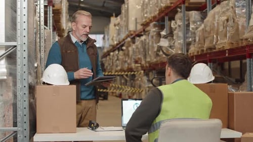 Warehouse Managers Discussing Merchandise of Goods at Workplace