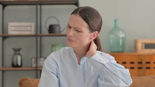 Woman Massaging Stiff Neck Muscles for Pain Relief