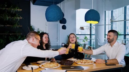 Colleagues Toasting Glasses Over Pizza in Modern Office