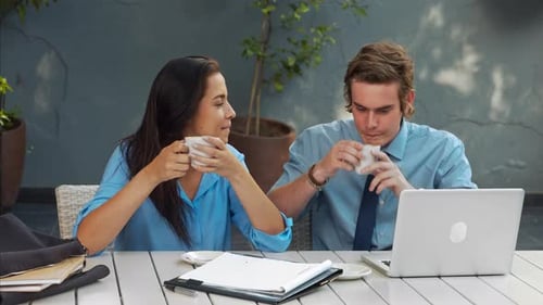 Colleagues Working Together at Outdoor Cafe with Coffee