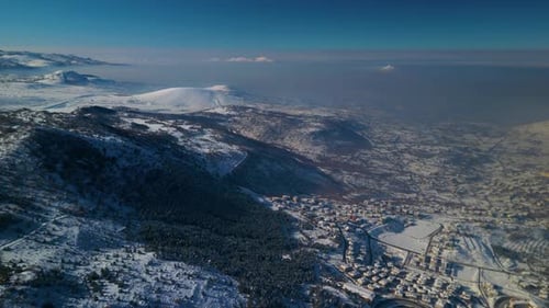 Winter Cityscape Surrounded by Snow-Capped Mountains