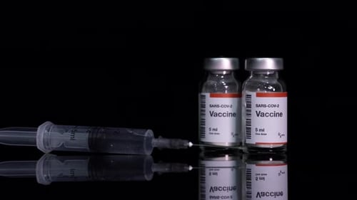 SARS-CoV-2 Vaccine and Syringe on Black