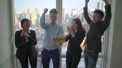 Excited Business Team Celebrates Success With Tablet