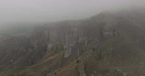 Aerial view of rocky mountains under fog, Armenia.