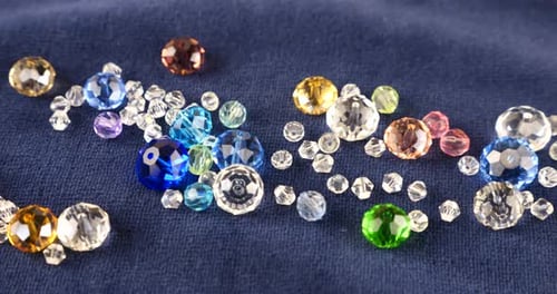 Multi-colored transparent jewelry crystals and rock crystal on blue velvet.