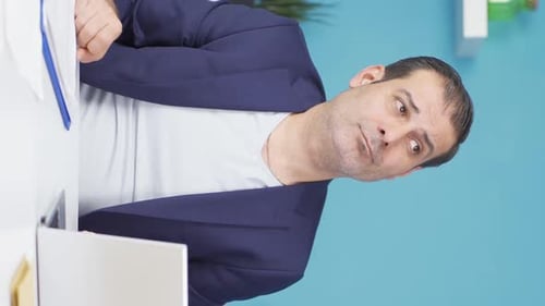 Man in Suit Gesturing at Desk in Office