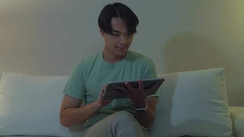 Young Adult Using Tablet Device on Couch