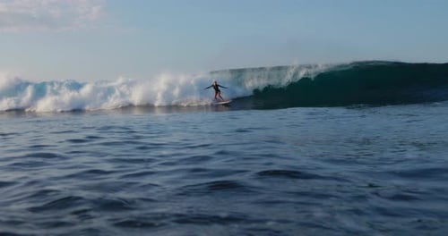 Surfer Rides a Wave in Tropical Ocean