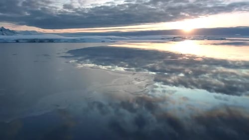 Coucher de soleil sur l'océan Arctique reflété dans l'eau glacée