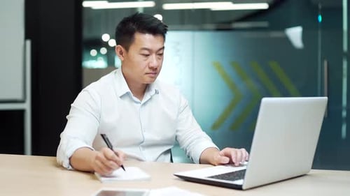 Focused businessman study online watching webinar. Asian business man employee studies video