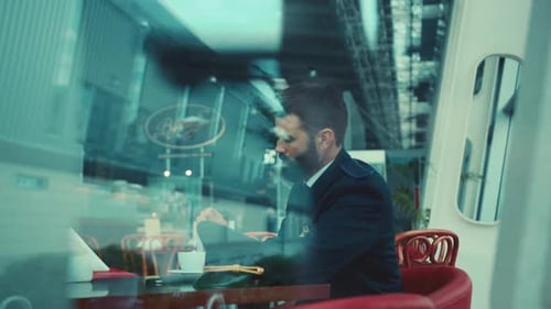 Close Up View of Goodlooking Bearded Pilot Sitting in Airport Caf and Drinking Coffee with Milk