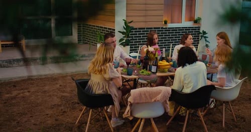 Friends Enjoying Meal Together Outdoors in Backyard