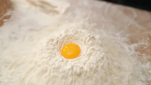 Egg Falls Into White Flour